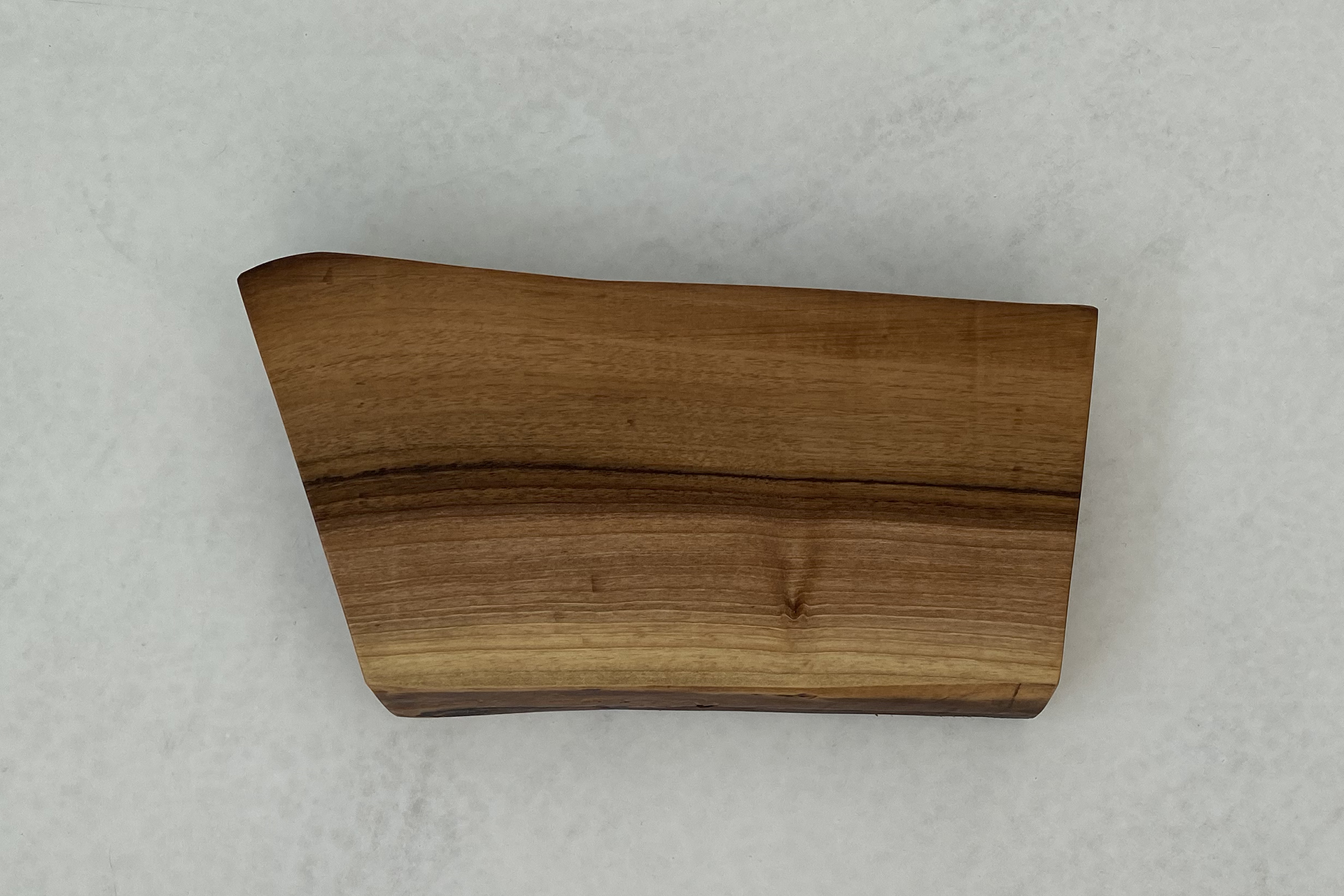 deski do krojenia i serwowania - deska z drewna orzecha włoskiego na tle białego mikrocementu